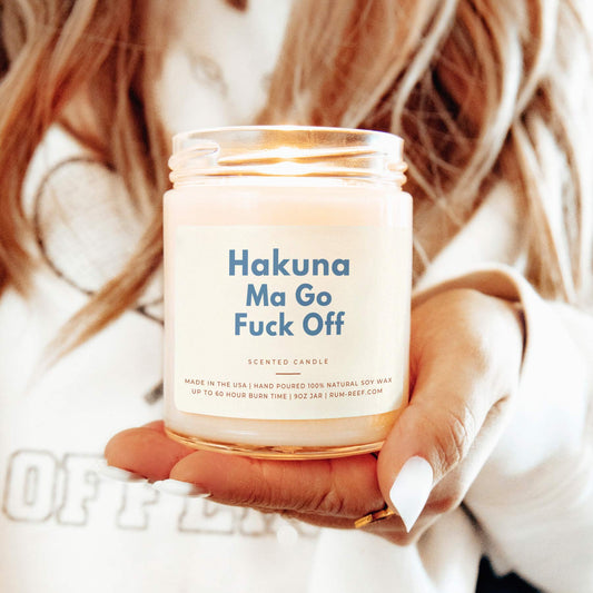 Hakuna Ma Go Fuck Off 9oz Candle held by a women.